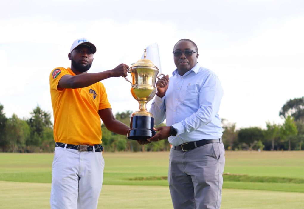 Nanyuki Sports club chairperson Paul Mwangi hands trophy to champion Cyprian Bundi.PHOTO/Eric Ngure