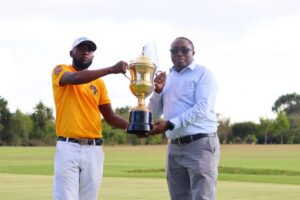 Nanyuki Sports club chairperson Paul Mwangi hands trophy to champion Cyprian Bundi.PHOTO/Eric Ngure